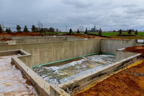 Concrete foundation walls and footing prepared with below grade waterproofing membrane